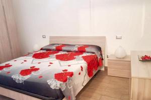 a bedroom with a bed with red flowers on it at 2 bedrooms apartement with sea view furnished terrace and wifi at Pianoconte 2 km away from the beach in Piano Conte