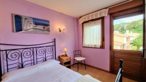 a bedroom with a bed and a large window at Aprtamento El Llagu Zolitru in Llanes