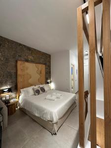 - une chambre avec un lit et un mur en pierre dans l'établissement Aelia Studios, à Aegiali