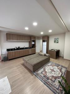 ein großes Wohnzimmer mit einem Bett und einer Küche in der Unterkunft Kitnet 5 in Rio Negrinho