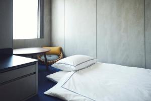 voco Osaka Central, an IHG Hotel في أوساكا: غرفة نوم بسرير وطاولة وكرسي