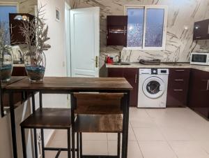 a kitchen with a table and a washing machine at Little Chatty in Costa Calma