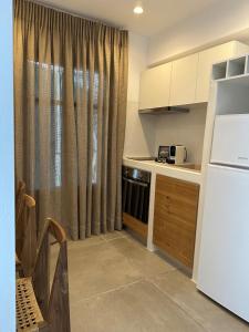 a kitchen with a white refrigerator and a window at Aelia Studios in Aegiali