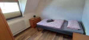 um pequeno quarto com uma cama e uma janela em FeWo Alte Schmiede em Oberlangfurth