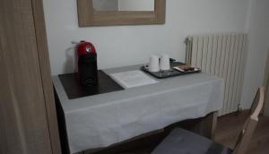 stół z czerwonym urządzeniem na górze w obiekcie Albergo Giardinetto w mieście Bellagio