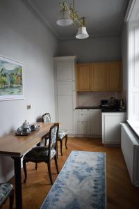a kitchen with a wooden table and chairs in a room at Augsburg Apart in Piatra Neamţ