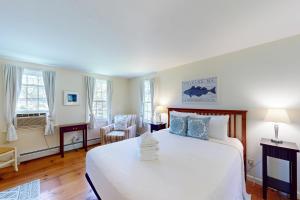 - une chambre avec un grand lit blanc et des oreillers bleus dans l'établissement Gray Gables, à Orleans