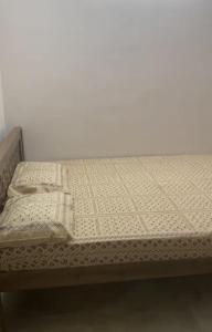 una cama con dos almohadas encima en Zara Apartments, en Chennai