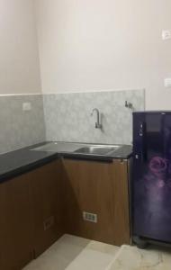 una cocina con fregadero y frigorífico en Zara Apartments, en Chennai