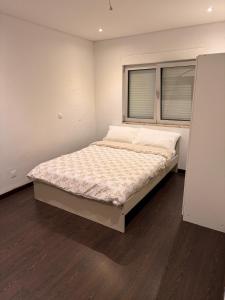 a large bed in a room with a window at Odivelas Inn in Odivelas