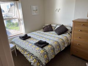 1 dormitorio con 1 cama con toallas en Dot's Cottage en Instow