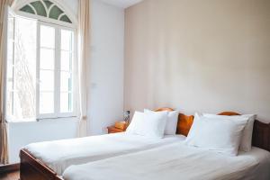 twee bedden in een kamer met een raam bij Semiramis Boutique Hotel & Spa in Kato Platres
