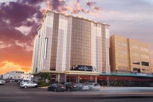 a tall building with cars parked in a parking lot at فندق فاندال in Jazan