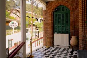 a porch with a green door and a checkered floor at Semiramis Boutique Hotel & Spa in Kato Platres