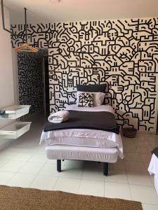 sypialnia z łóżkiem z czarno-białą wzorzystą ścianą w obiekcie Nomadia Hostel Boutique w mieście Bogota