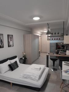 uma cama branca num quarto com uma cozinha em Cozy Di.Va city centre em Tessalónica