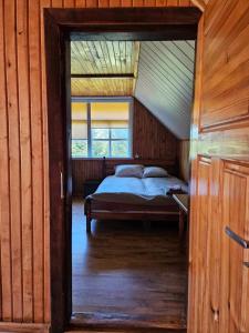 a bedroom with a bed in a wooden house at Šauklių pirtelė in Šaukliai +12 photos