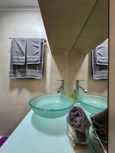 łazienka z 2 szklanymi umywalkami i ręcznikami w obiekcie URBAN APARTMENT w mieście Amaliada