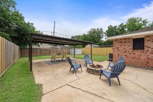 eine Terrasse mit 4 Stühlen und einer Feuerstelle in der Unterkunft Seabrook Sanctuary Cozy 3BR Home Perfect for Families Privacy & Comfort Galore in Seabrook
