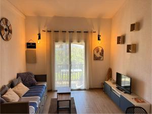 a living room with a couch and a tv at Appartement Duplex 4pers Climatisé - Location Valadié Camargue in Saintes-Maries-de-la-Mer