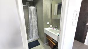 a bathroom with a sink and a shower curtain at Encantador Depto en Cañitas Palermo in Buenos Aires