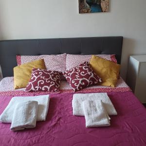 Una cama morada con un montón de almohadas. en B&B Appartamenti Napoli, en Nápoles