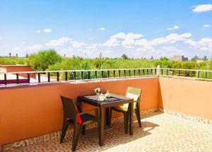 a patio with a table and chairs on a balcony at Riad Nasma Souihla in Marrakesh