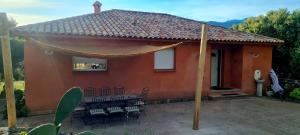 una casa con un tavolo e sedie di fronte di Villa A LICCIA a Figari Altre 32 foto