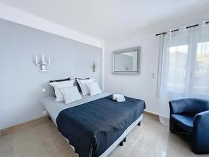 a bedroom with a bed and a blue chair at Two en-suite bedroom apartment on La Croisette - Sea view in Cannes