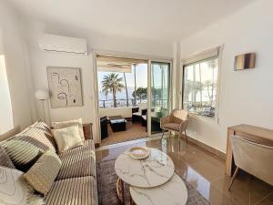 een woonkamer met een bank en een tafel bij Two en-suite bedroom apartment on La Croisette - Sea view in Cannes