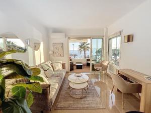 sala de estar con sofá y mesa en Two en-suite bedroom apartment on La Croisette - Sea view, en Cannes