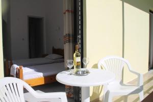a table and chairs with a bottle of wine and a bed at Kavos Central Gardens in Kavos