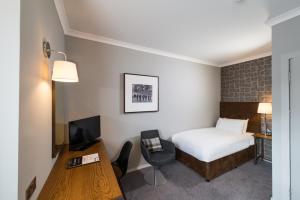 um quarto de hotel com uma cama e uma secretária em Glasgow West Hotel by Compass Hospitality em Glasgow