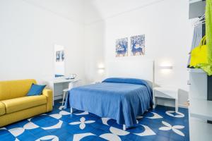 - une chambre avec un lit et une chaise jaune dans l'établissement Villa Azzurra, à Vico Equense