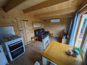 a kitchen and living room with a stove and a chair at Cosy Cabin in Stock +25 photos