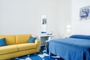 - une chambre avec un lit et un canapé jaune dans l'établissement Villa Azzurra, à Vico Equense