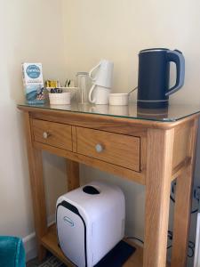 una mesa con tostadora y otros artículos. en Lynwood House Bed and Breakfast, en Tregoney