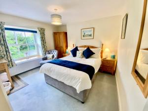 a bedroom with a large bed and a window at Lynwood House Bed and Breakfast in Tregoney
