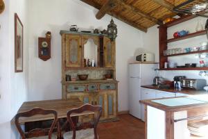 a kitchen with a wooden table and a white refrigerator at Montes de Baixo in Odeceixe