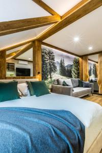 a bedroom with a large bed and a couch at Apartamenty ForRest Krupówki in Zakopane