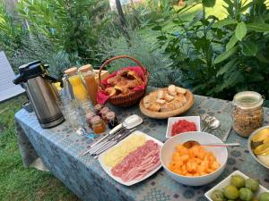 a table with cheese and other foods on it at Au Pré Fleuri Eco Glamping in Le Lindois