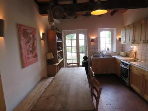 een keuken met een lange houten tafel in een kamer bij L'Atelier d'Azas in Azas