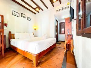 a bedroom with a bed and a tv on a wall at khong kham Hotel in Luang Prabang +18 photos