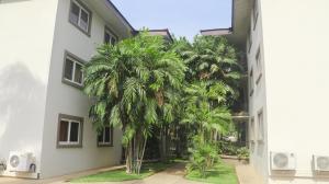 un grupo de palmeras frente a un edificio en Palm Court en Accra