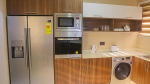 eine Küche mit einem Kühlschrank und einer Mikrowelle in der Unterkunft Palm Court in Accra