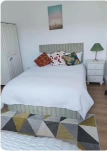 una camera da letto con un grande letto bianco con cuscini di Town Center 3Room House free parking a Letterkenny