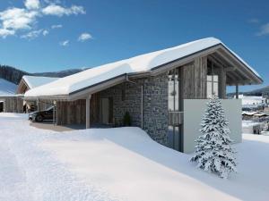 un edificio cubierto de nieve con un árbol delante en Grebenzen Lodge 51A, en Sankt Lambrecht