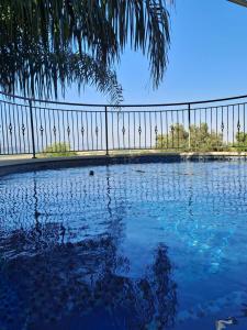 una piscina de agua frente a una valla en Vila Manor, en Midrakh ‘Oz