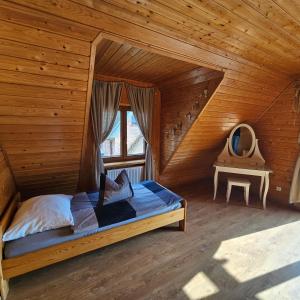 コウチェボにあるZakatek Malaの木製の部屋にベッド1台が備わるベッドルーム1室があります。