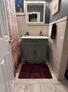 uma casa de banho com um lavatório verde e um espelho em Secluded Country Getaway em Highland